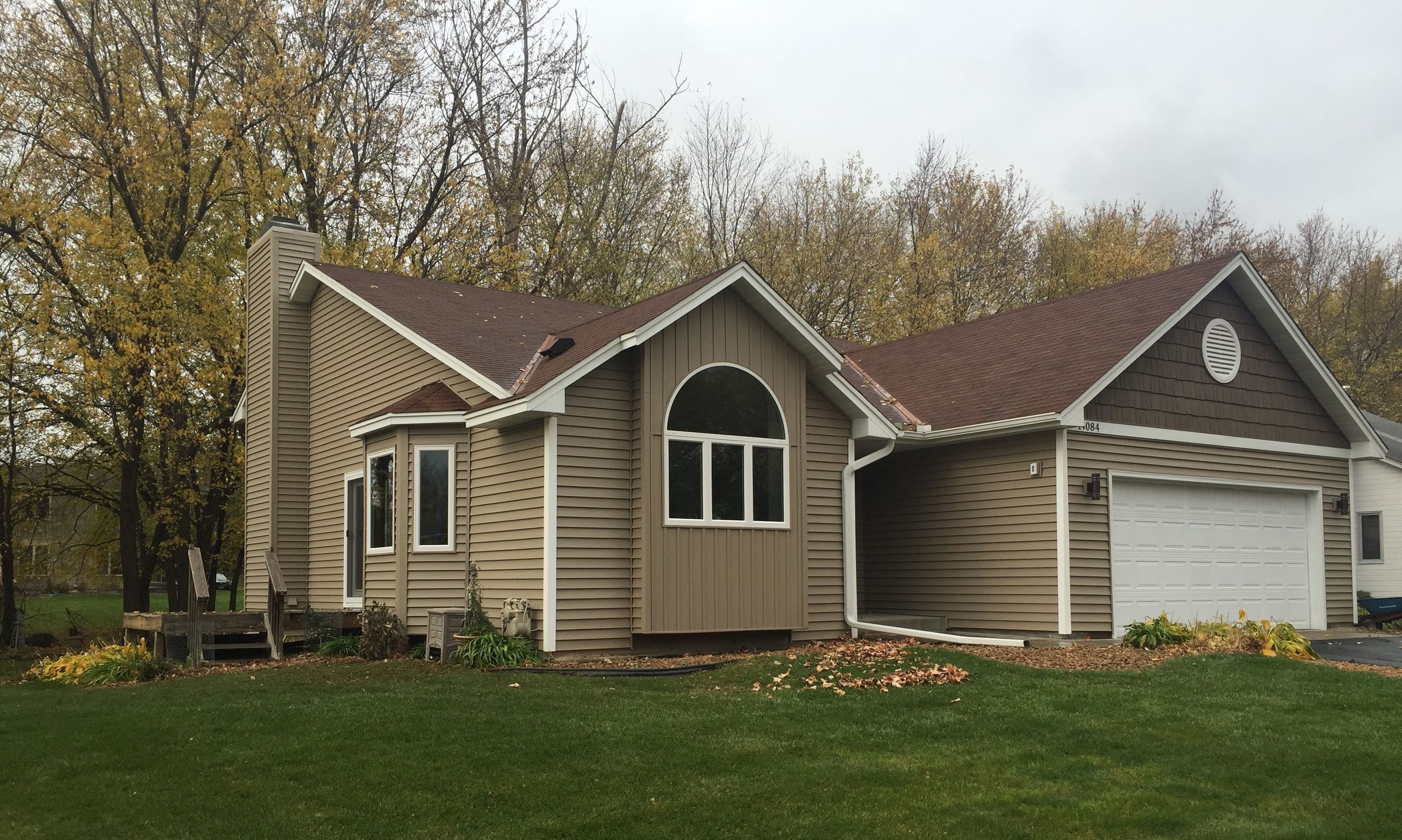 Same house after re-siding in tan vinyl with new Windows